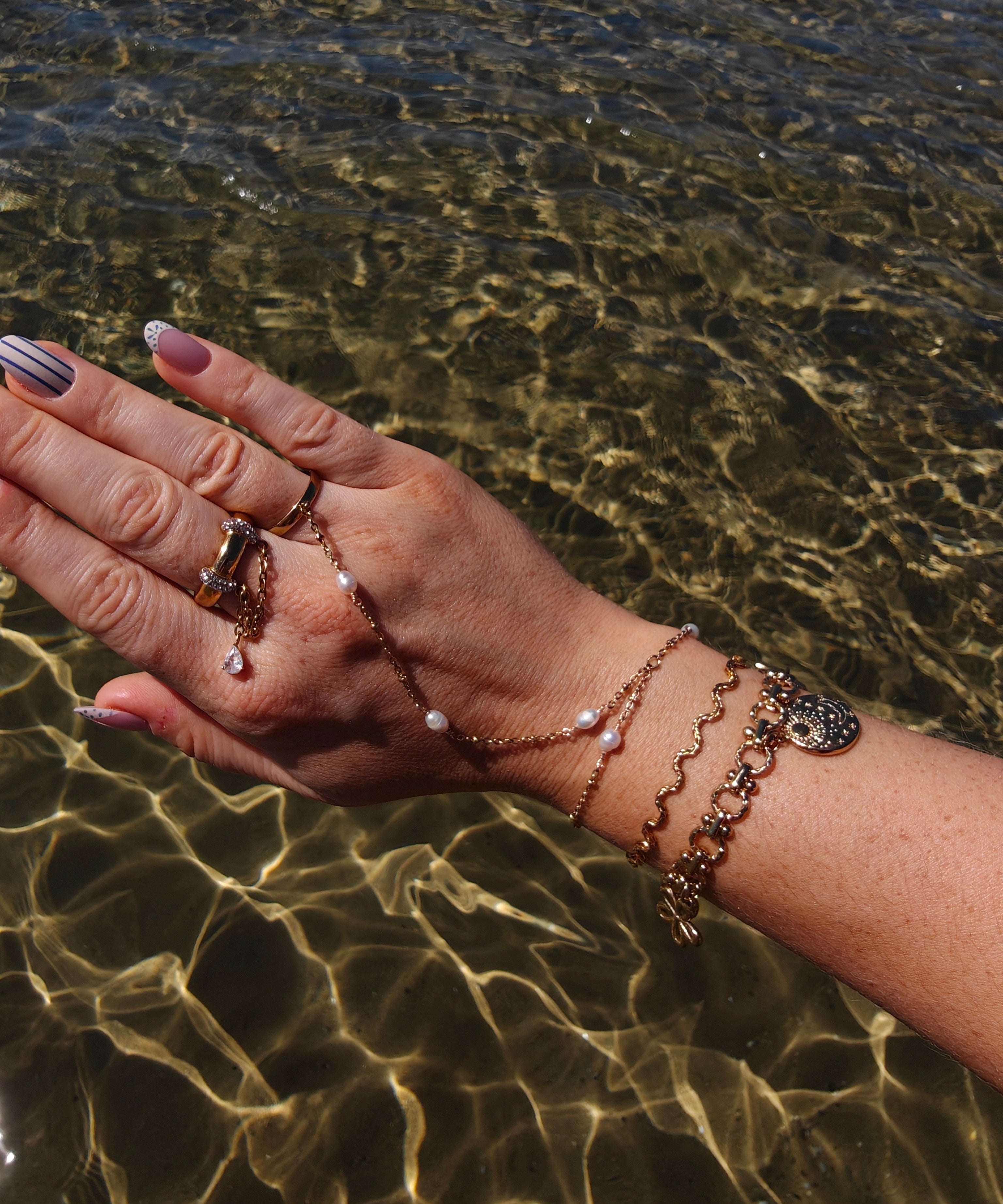 Coquette gouden armband met bloemen, een hart en medaillons | gedragen