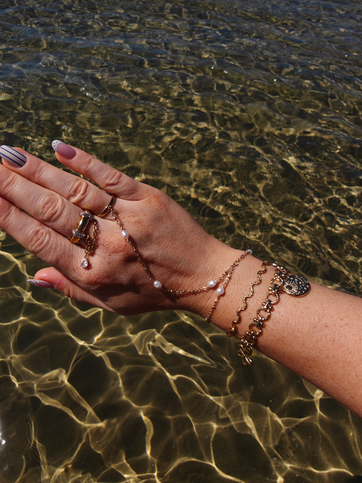 Coquette gouden armband met bloemen, een hart en medaillons