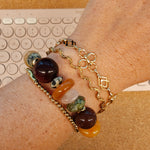 Gouden BLOSS armbanden gecombineerd met een edelstenenarmband